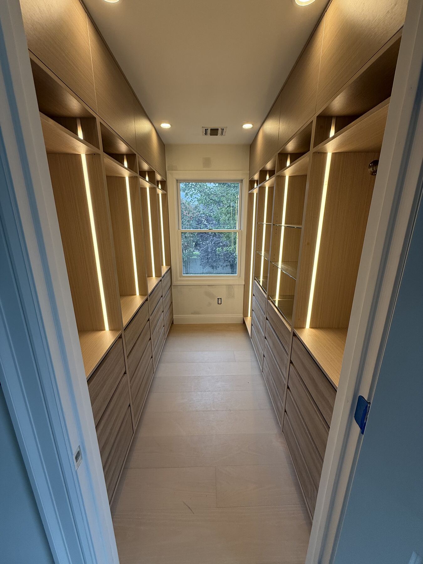 Walk-in closet corridor with natural light
