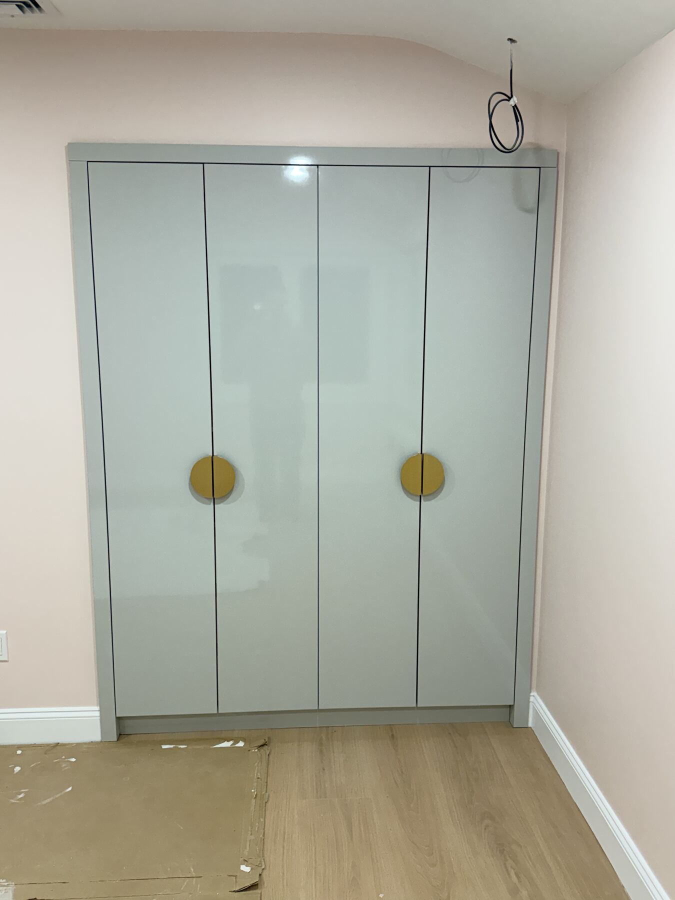 Glossy grey wardrobe with round brass handles