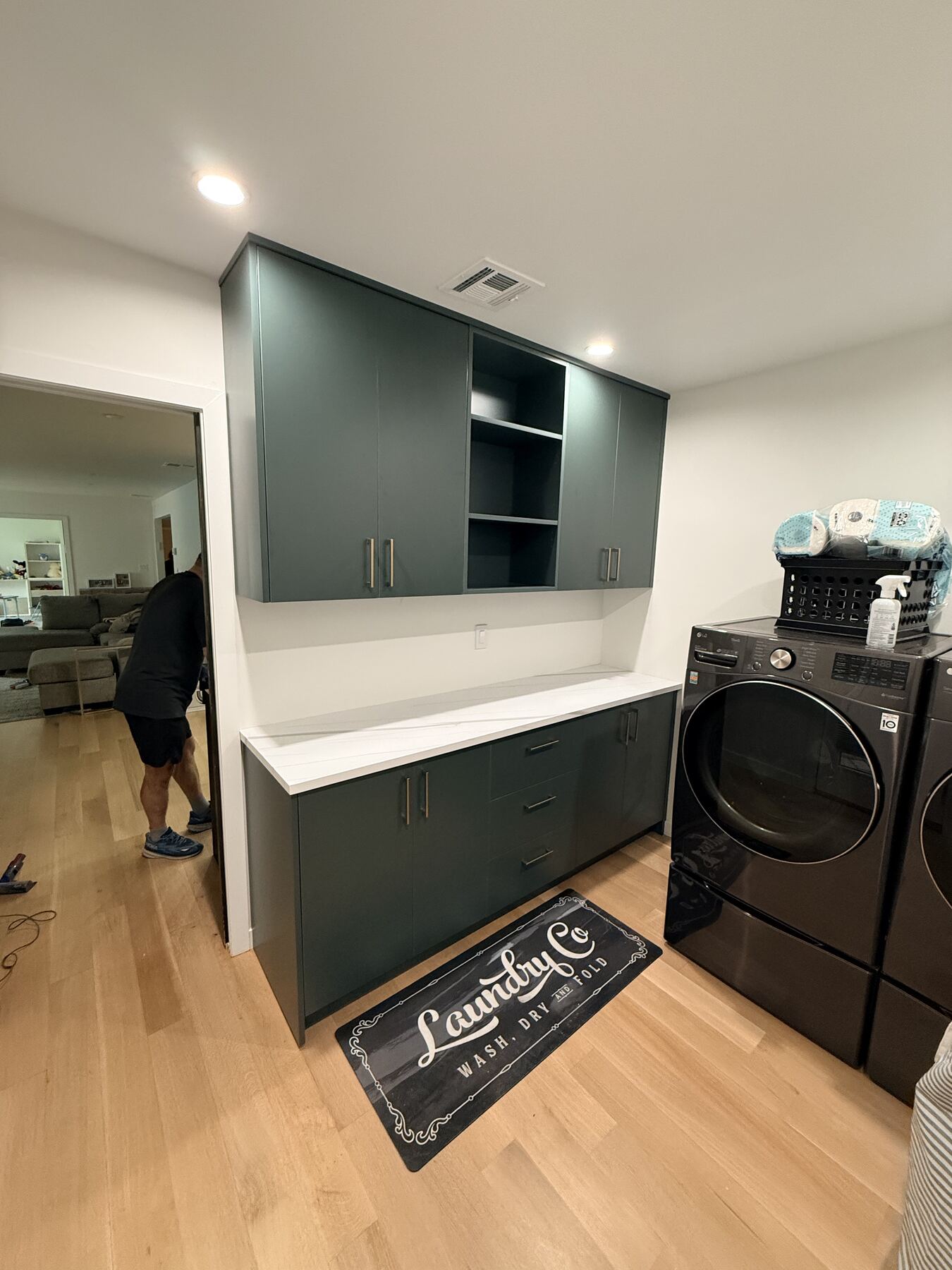 Laundry room cabinetry in forest green with quartz counter