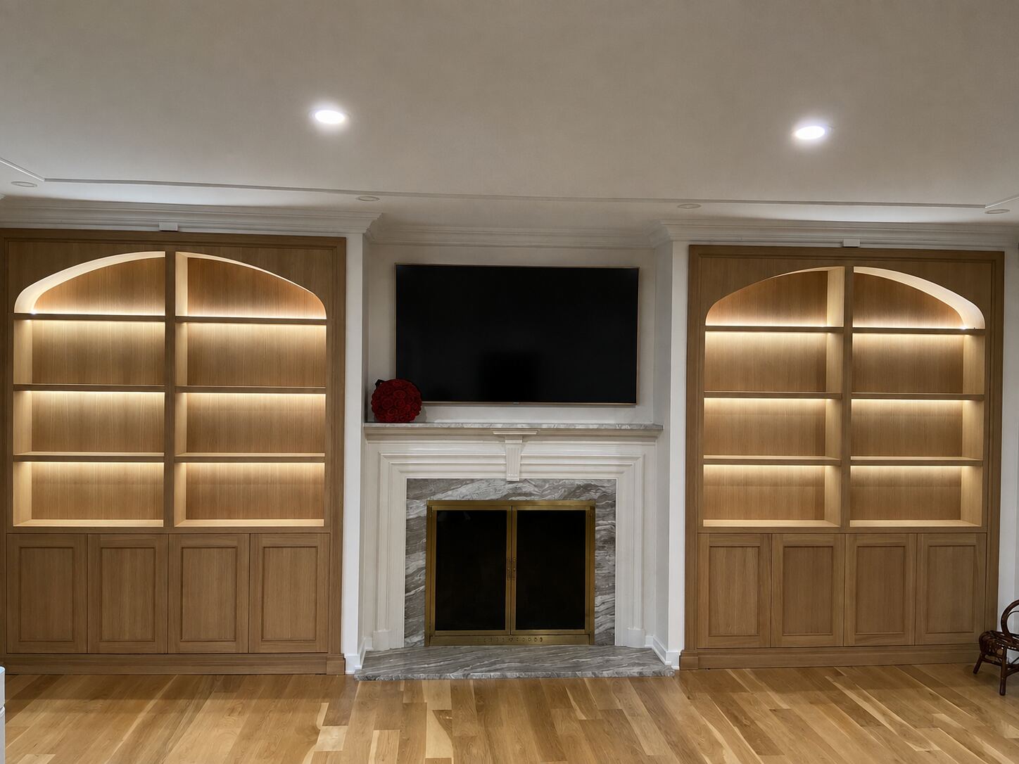 Fireplace media wall with arched built-in bookshelves