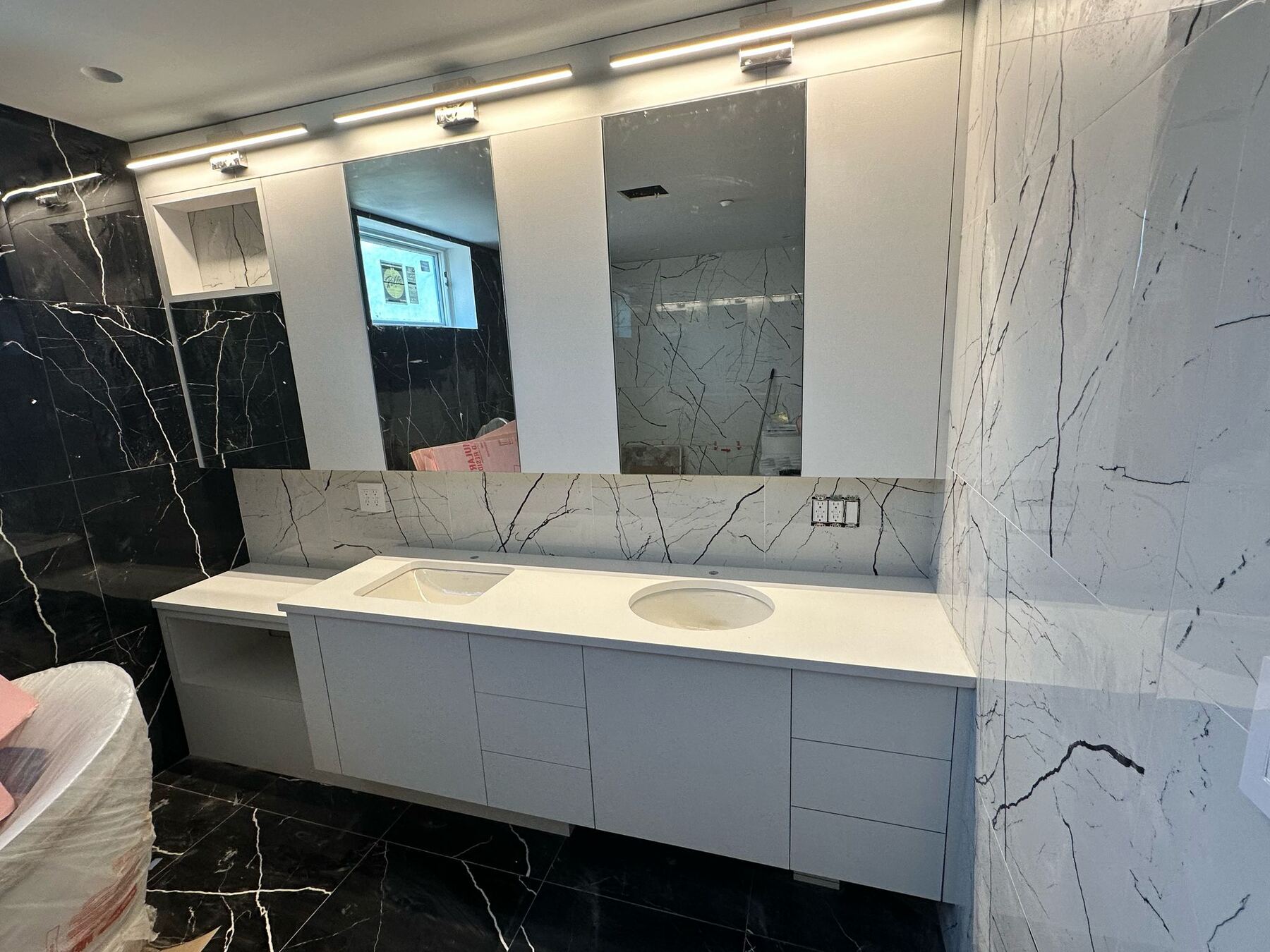 Double bathroom vanity with white cabinetry and marble backsplash