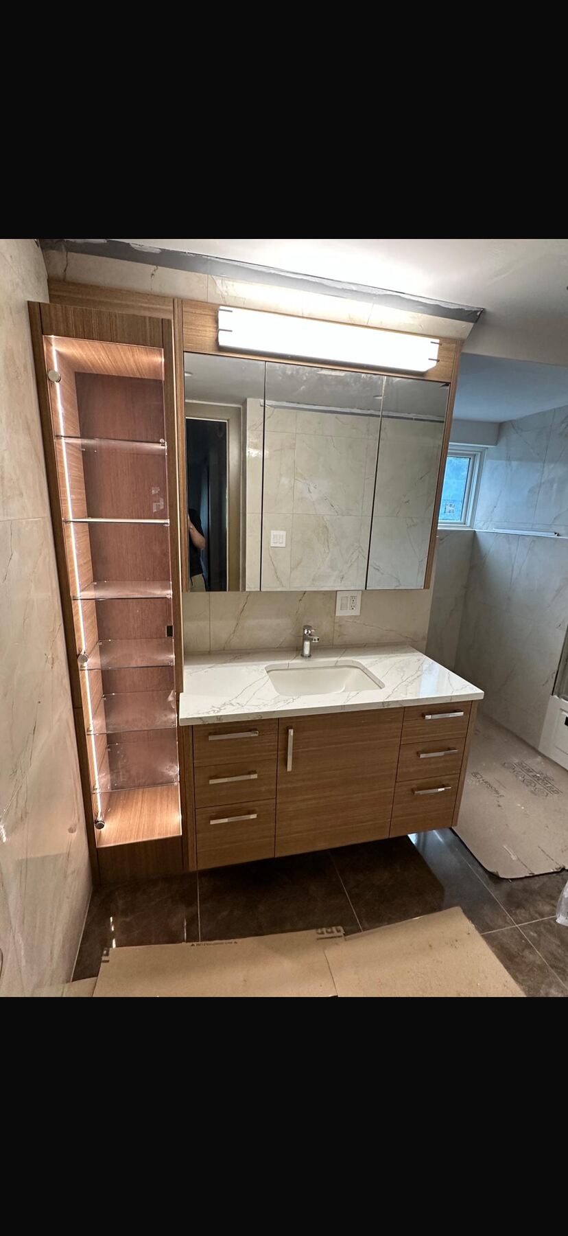 Wood grain vanity with lit glass shelving tower